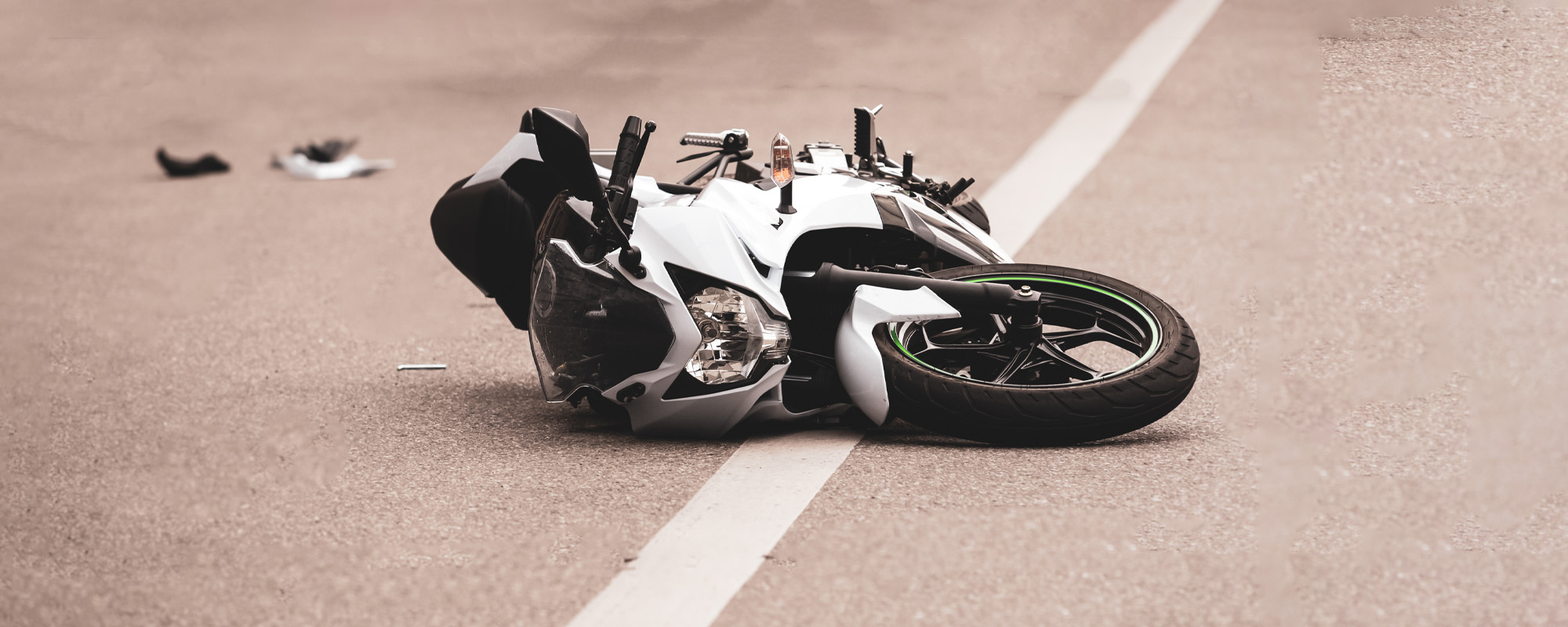 broken motorcycle lies on the road